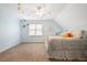 A spacious bedroom with light blue walls and a large window featuring a sloped ceiling at 6011 Fairlong Nw Ct, Acworth, GA 30101