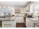 Bright kitchen boasts granite counters, white cabinetry, island with pendant lighting, and stainless steel appliances at 6011 Fairlong Nw Ct, Acworth, GA 30101