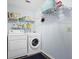 Functional laundry room with a washer, dryer, storage shelves, and simple decor for efficient chores at 6011 Fairlong Nw Ct, Acworth, GA 30101