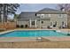 A backyard features a sparkling in-ground swimming pool and the home's exterior at 6011 Fairlong Nw Ct, Acworth, GA 30101