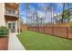 Serene backyard featuring a lush lawn, iron fence, a small patio and mature trees at 1803 Stone Bridge Way, Marietta, GA 30064