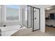 Bathroom featuring a glass-enclosed shower, soaking tub, and walk-in closet access at 1803 Stone Bridge Way, Marietta, GA 30064