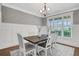 Elegant dining room featuring wainscoting, a modern chandelier, and large windows for natural light at 1803 Stone Bridge Way, Marietta, GA 30064