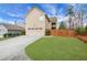 Rear exterior of a two-story house with a two-car garage, driveway, and green lawn at 1803 Stone Bridge Way, Marietta, GA 30064