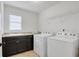 Bright laundry room with a sink, black cabinets, and white washer and dryer at 1803 Stone Bridge Way, Marietta, GA 30064