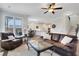 Comfortable living room with leather furniture, ceiling fan, and natural light from large windows at 1803 Stone Bridge Way, Marietta, GA 30064