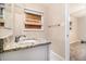 Bathroom featuring granite countertop, sink, mirror, and wood-look flooring at 2131 Columbia Dr, Decatur, GA 30032