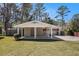 Exterior home view with carport, front lawn, and mature trees under blue sky at 2131 Columbia Dr, Decatur, GA 30032