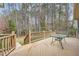 Wooden deck with a glass table overlooking a lush, wooded backyard at 2290 Dragonfly Nw Ct, Acworth, GA 30101