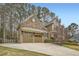 Charming home with a two-car garage and long driveway, complemented by lush landscaping and mature trees at 2290 Dragonfly Nw Ct, Acworth, GA 30101