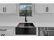 Close-up of a farmhouse style kitchen sink, black faucet, and butcher block cutting board at 2430 Hanford Sw Dr, Atlanta, GA 30315