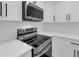 Close up on stainless steel oven and microwave nestled in bright white kitchen cabinetry at 2430 Hanford Sw Dr, Atlanta, GA 30315