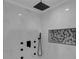Modern walk-in shower features beautiful marble-like tile, black fixtures, and built-in shelving at 2430 Hanford Sw Dr, Atlanta, GA 30315