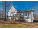 Home's back exterior featuring a deck and stairs, set against a backdrop of mature trees and lush greenery at 210 Barrett Springs Way, Canton, GA 30115