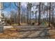 A large wooded backyard featuring a fire pit and playset at 210 Barrett Springs Way, Canton, GA 30115