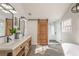 Bright bathroom featuring a double vanity, a sliding barn door, and a glass shower at 210 Barrett Springs Way, Canton, GA 30115