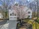 Charming two-story home with a well-manicured lawn and a beautiful flowering tree in the front yard at 210 Barrett Springs Way, Canton, GA 30115
