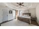 Cozy main bedroom with a tray ceiling, a barn door, and a decorative ceiling fan at 210 Barrett Springs Way, Canton, GA 30115