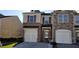 Charming townhome featuring brick and siding exterior, garage, and well-maintained landscaping at 2102 Executive Dr, Duluth, GA 30096