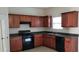 Functional kitchen offering wood cabinets, dark countertops, a black dishwasher, and a range at 2102 Executive Dr, Duluth, GA 30096