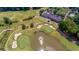 Aerial view of golf course, showcasing manicured greens, sand traps, ponds, and the clubhouse, surrounded by trees at 7085 Wakehurst Pl, Cumming, GA 30040