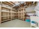 Unfinished basement offering great storage solutions with wooden shelving and a utility sink at 7085 Wakehurst Pl, Cumming, GA 30040