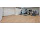Spacious basement with exercise equipment, light laminate flooring, and white storage cabinets at 7085 Wakehurst Pl, Cumming, GA 30040