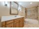 Well-lit bathroom featuring a vanity with drawers, tiled shower, and updated fixtures at 7085 Wakehurst Pl, Cumming, GA 30040