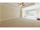 Spacious carpeted bedroom with tray ceiling, ceiling fan, and a large window at 7085 Wakehurst Pl, Cumming, GA 30040