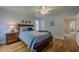 Bedroom features hardwood floors, ceiling fan, and ensuite access to bathroom at 7085 Wakehurst Pl, Cumming, GA 30040
