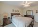 Cozy bedroom featuring a ceiling fan, wood furniture, and comfortable neutral colored bedding at 7085 Wakehurst Pl, Cumming, GA 30040
