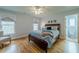 Bedroom with hardwood floors, ceiling fan, and ensuite bathroom access at 7085 Wakehurst Pl, Cumming, GA 30040