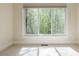 Bedroom featuring neutral carpet, a large window with wooded views, and sunlight at 7085 Wakehurst Pl, Cumming, GA 30040
