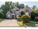Traditional two-story brick home with manicured front yard at 7085 Wakehurst Pl, Cumming, GA 30040