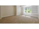 Neutral toned living room with a large window and built in shelves at 7085 Wakehurst Pl, Cumming, GA 30040