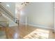 Open-concept living room with hardwood floors, staircase, and abundant natural light at 7085 Wakehurst Pl, Cumming, GA 30040