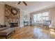 Cozy living room with a stone fireplace, hardwood floors, and large windows at 7085 Wakehurst Pl, Cumming, GA 30040
