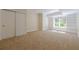 Carpeted living room featuring a closet and built in shelving surrounding a window at 7085 Wakehurst Pl, Cumming, GA 30040