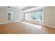 Well-lit living room with hardwood floors and a large window overlooking the outdoor scenery at 7085 Wakehurst Pl, Cumming, GA 30040
