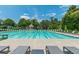 Relaxing swimming pool featuring lounge chairs, clear blue water, and lush green landscaping in a vibrant community setting at 7085 Wakehurst Pl, Cumming, GA 30040
