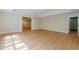 Large open room with laminate flooring and trim; a versatile space for entertaining or recreation at 7085 Wakehurst Pl, Cumming, GA 30040