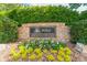 Stone Polo Golf & Country Club entrance sign surrounded by greenery and colorful flowers at 7085 Wakehurst Pl, Cumming, GA 30040
