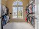Walk-in closet featuring built-in shelving and natural light from a large window at 7085 Wakehurst Pl, Cumming, GA 30040