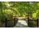 Scenic community walking path with bridge and gazebo, surrounded by lush greenery and mature trees at 7085 Wakehurst Pl, Cumming, GA 30040