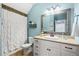 Bathroom showcasing a shower-tub combination, white vanity, and bright blue walls at 129 Euharlee 5 Forks Rd, Euharlee, GA 30145