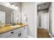 Bright bathroom featuring a golden countertop, white cabinetry, and a large mirror at 129 Euharlee 5 Forks Rd, Euharlee, GA 30145