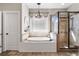 Bright bathroom features soaking tub beneath a window and a tiled walk-in shower at 129 Euharlee 5 Forks Rd, Euharlee, GA 30145