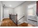 Hallway with hardwood floors, wood stair railing, and a view of a bedroom at 129 Euharlee 5 Forks Rd, Euharlee, GA 30145