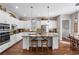 Modern kitchen features white cabinetry, an island with seating, and an adjacent dining area at 129 Euharlee 5 Forks Rd, Euharlee, GA 30145