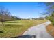 View of a spacious property with a long driveway leading to a charming house in the distance at 129 Euharlee 5 Forks Rd, Euharlee, GA 30145